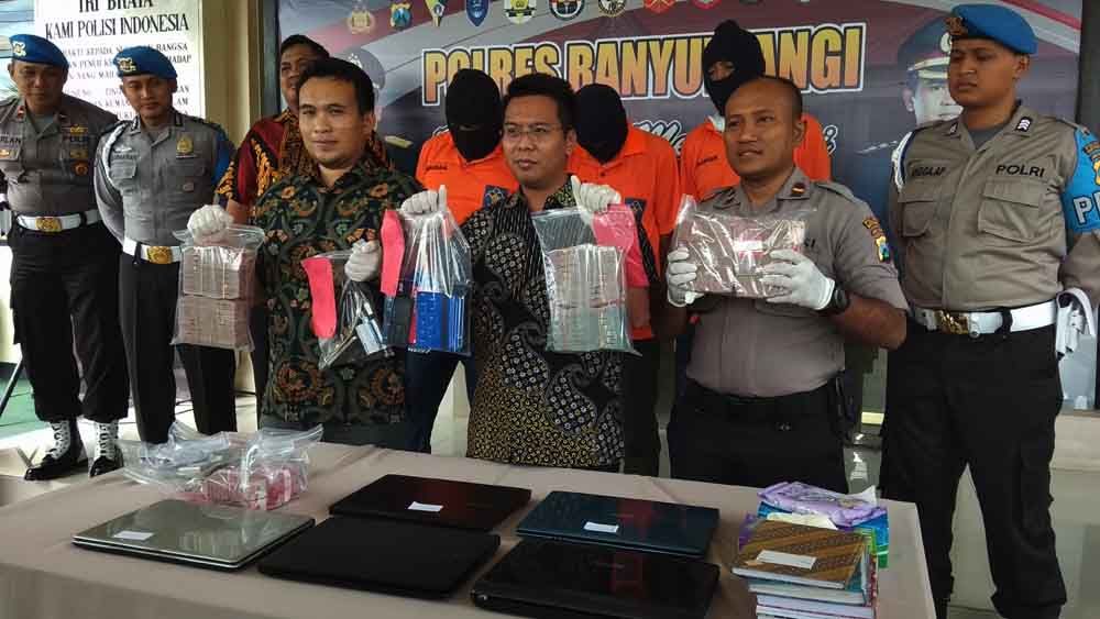 Kasat Reskrim Polres Banyuwangi, AKP Panji Pratistha Wijaya menunjukkan barang bukti berupa uang tunai ratusan juta