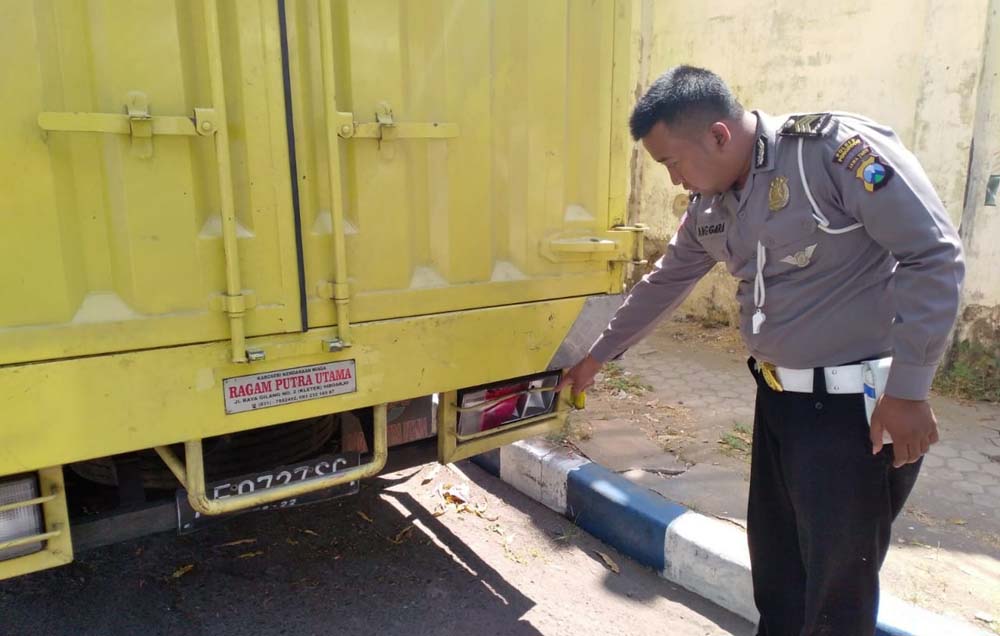 Petugas menunjukkan bekas tabrakan di belakang truk