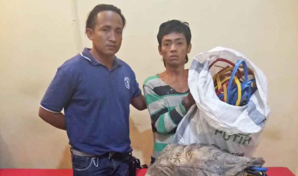 Herman (kanan) saat diamankan di Mapolsek Wonokromo bersama barang yang dicurinya. 