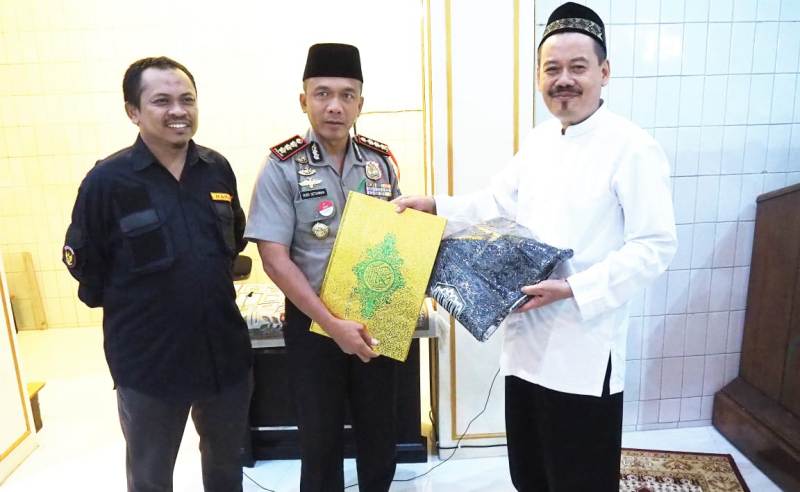 Kapolrestabes Surabaya saat memberikan Al-Quran dan sajadah kepada pengurus masjid.