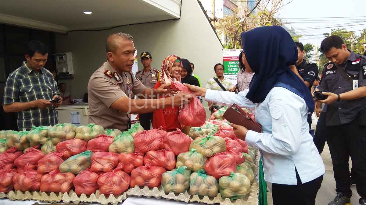 Kapolrestabes Surabaya Kombes Pol Rudi Setiawan saat berjualan telur di acara pasar murah jatimnow.com