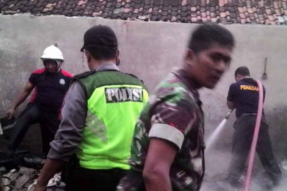 Petugas memadamkan api di rumah Miskun