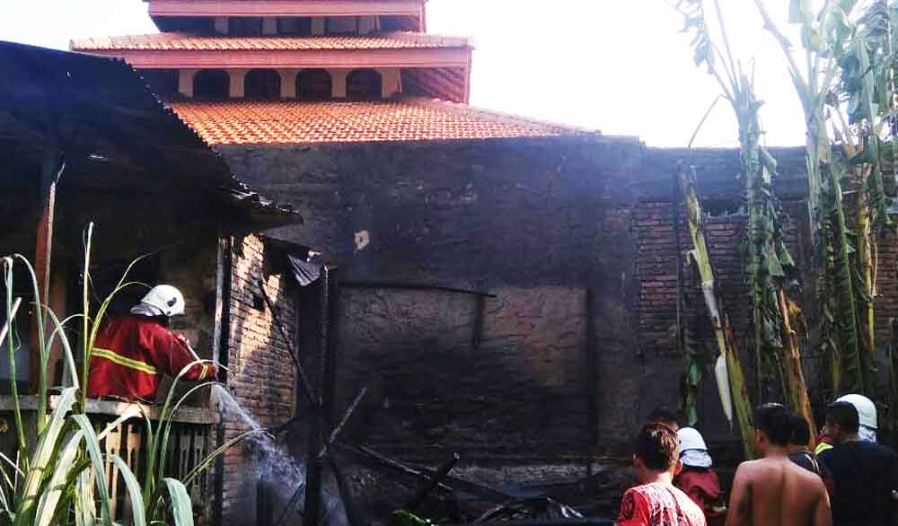 Petugas PMK melakukan pembasahan di rumah terbakar di Bojonegoro