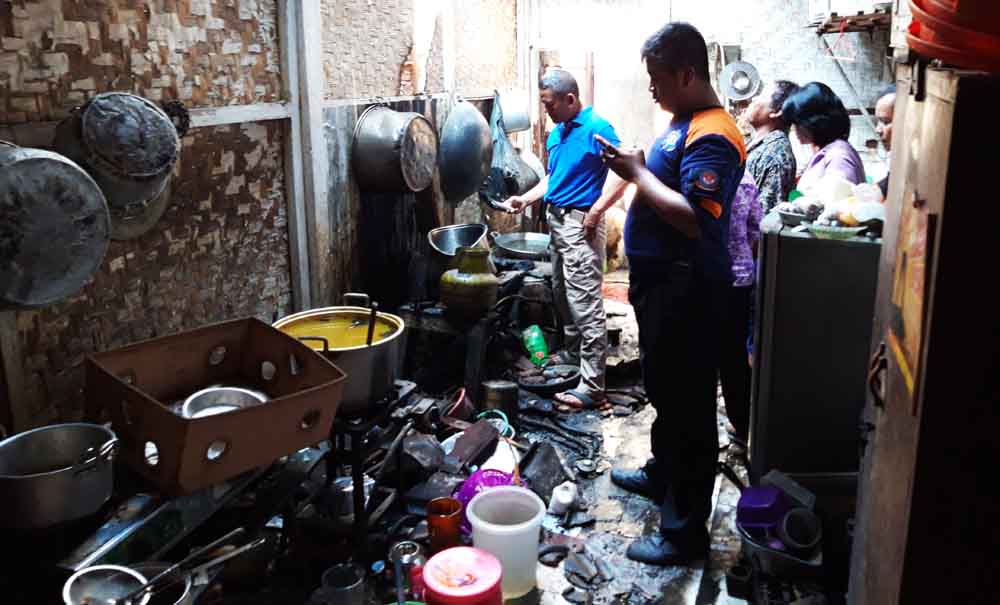 Petugas PMK memastikan api benar-benar padam di dapur rumah Warga Siwalan Kerto Surabaya, Selasa (11/9/2018).