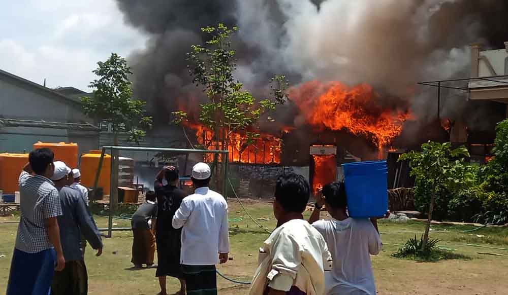 Para santri berupaya memadamkan kobaran api