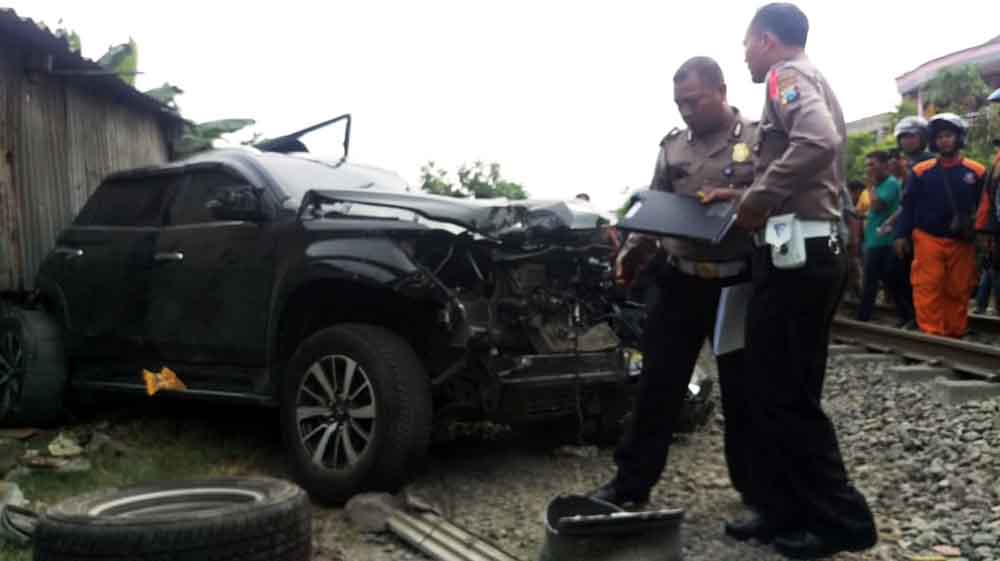 Petugas mengevakuasi puing-puing mobil Pajero