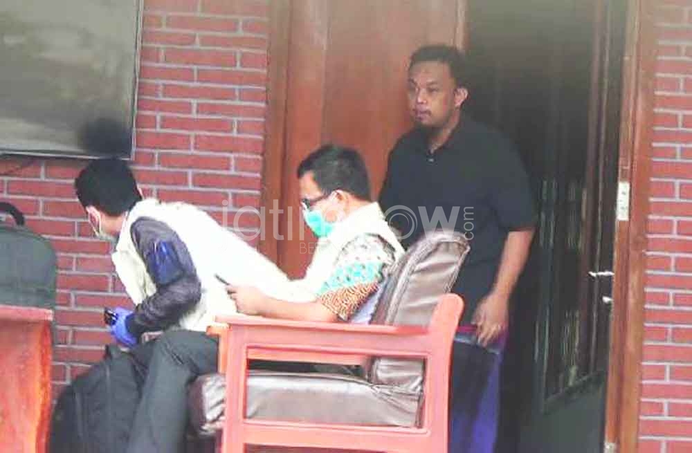 Henry (baju hitam) saat melayani kedatangan petugas KPK di rumahnya