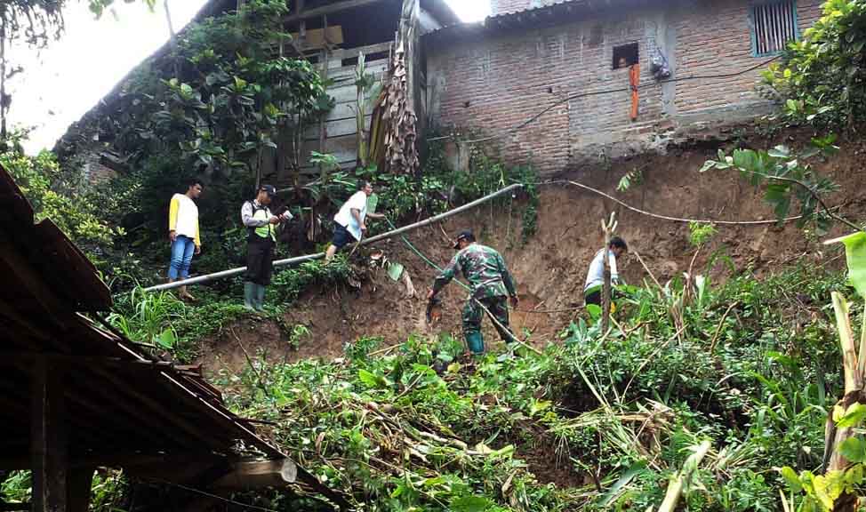 Warga dan petugas membersihkan sisa tanah longsor