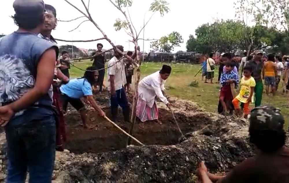Sejumlah warga menutup kembali liang lahat yang akan menjadi pemakaman terduga teroris.