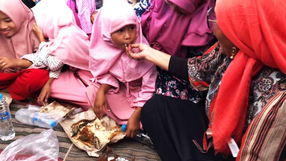 Menteri Susi menyuapkan ikan ke salah satu santri. Foto foto: Fajar Mujianto/ jatimnow.com