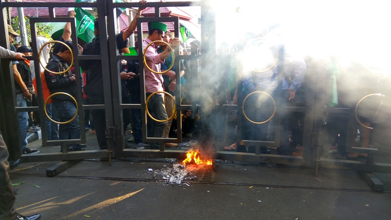 Massa aksi saat membakar kertas hingga pagar dewan nyaris terbakar, Jumat (14/9/2018).