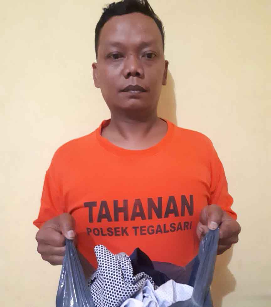Tersangka saat diamankan di Mapolsek Tegalsari Surabaya.