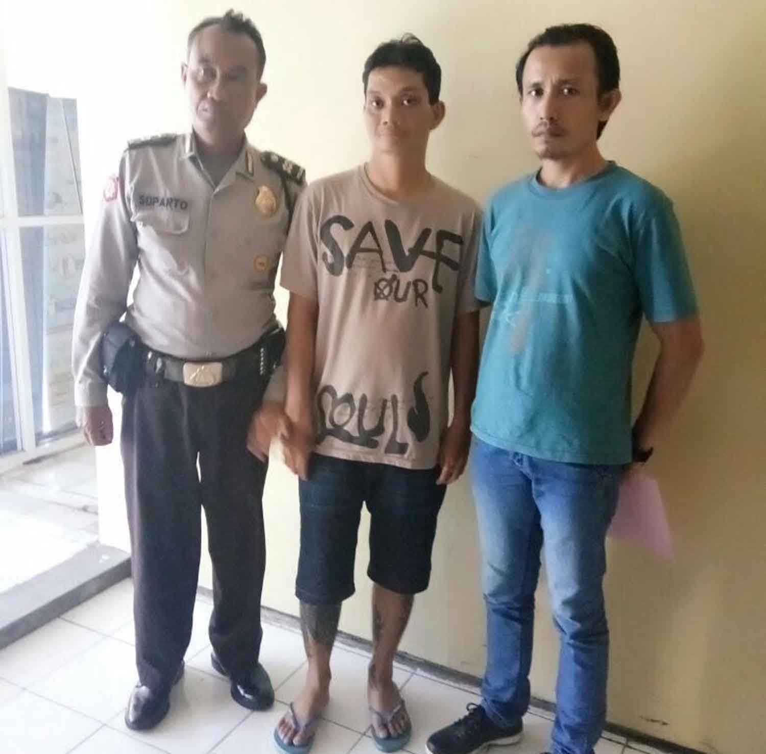 Sandie (tengah) saat diamankan di Mapolsek Sukomanunggal Surabaya.
