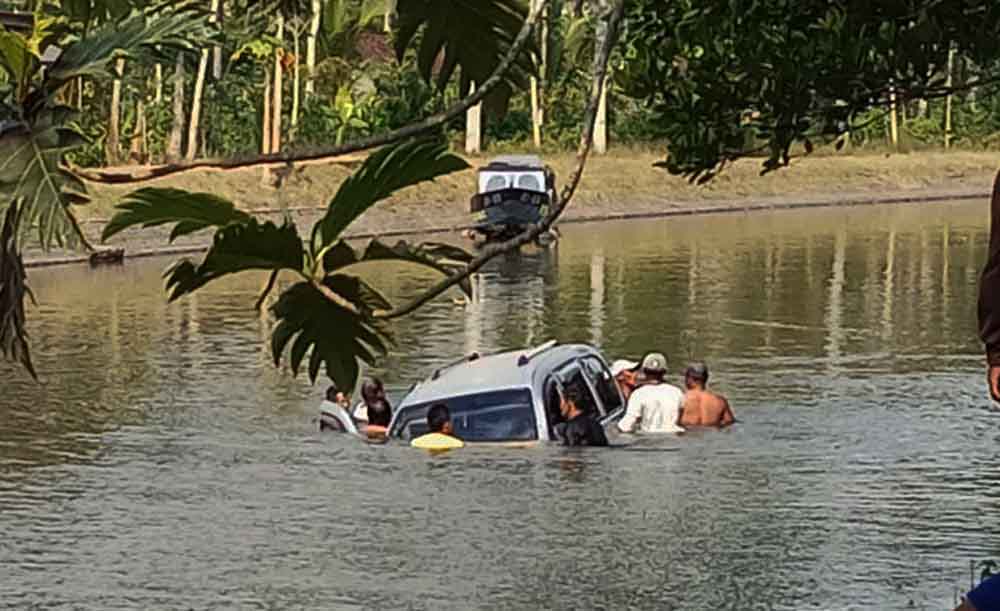 Warga berupaya mengevakuasi sopir dari mobil yang nyemplung ke sungai
