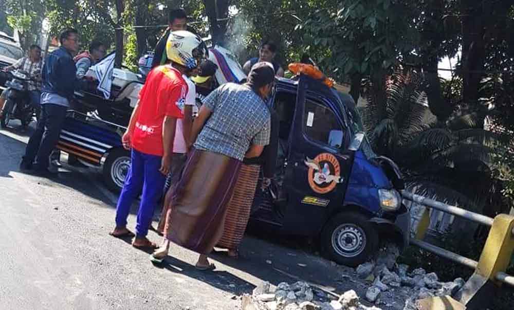 Warga berupaya menolong pikap yang menabrak pagar jembatan