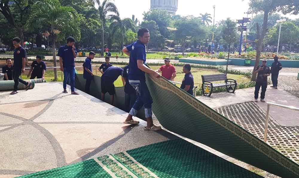 Para napi membersihkan karpet masjid