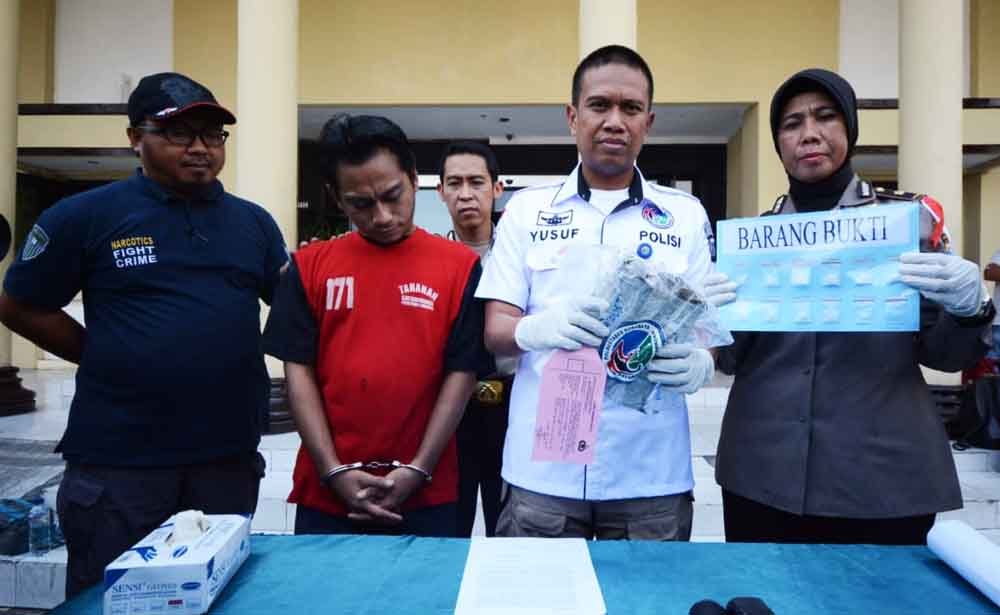 Tersangka bersama barang bukti saat di Mapolrestabes Surabaya
