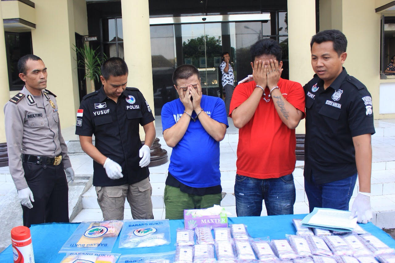 Petugas membeberkan barang bukti dan tersangka di Mapolrestabes Surabaya. 
