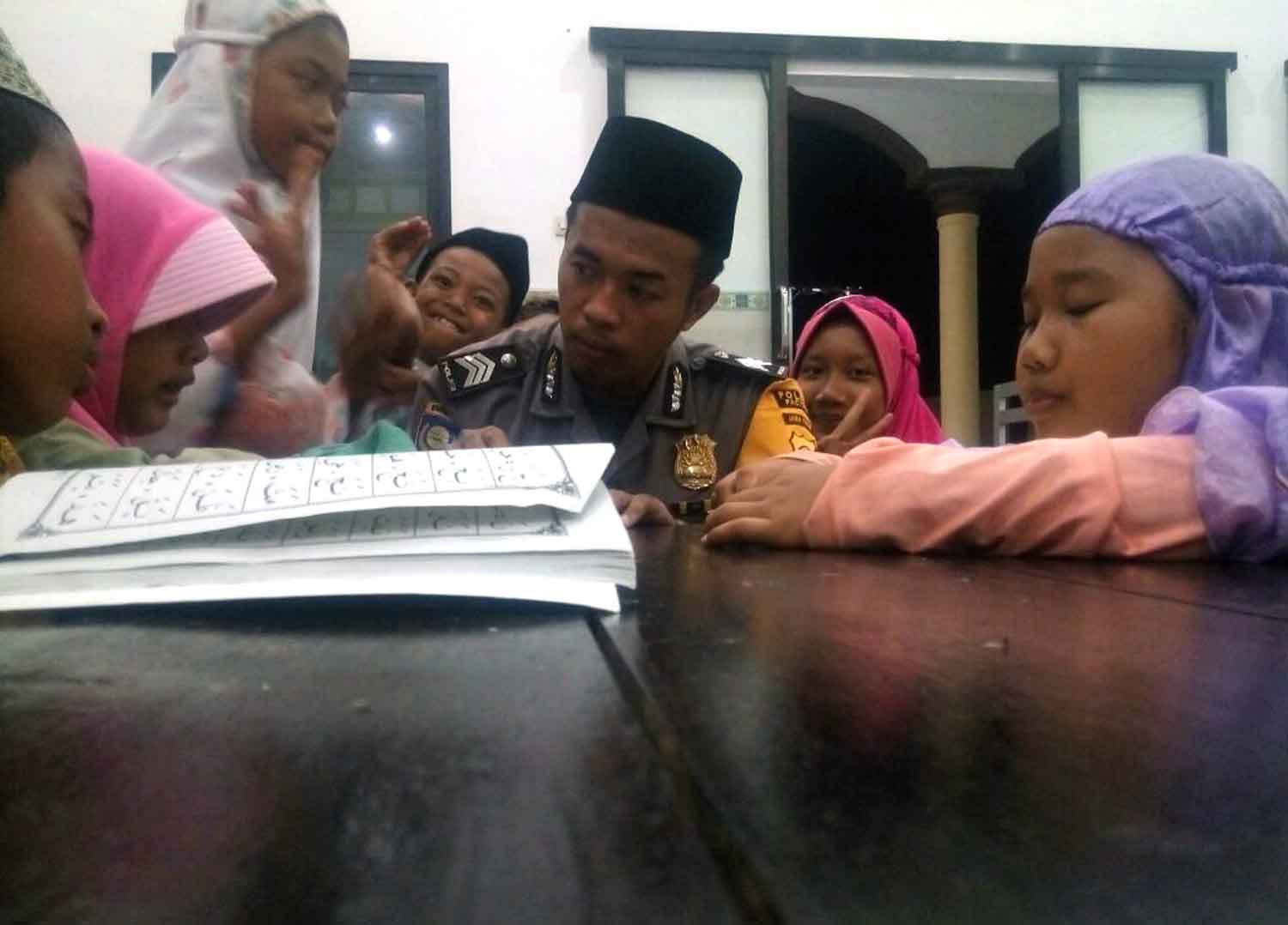 Brigadir Gatot mengajar anak-anak lingkungannya mengaji.