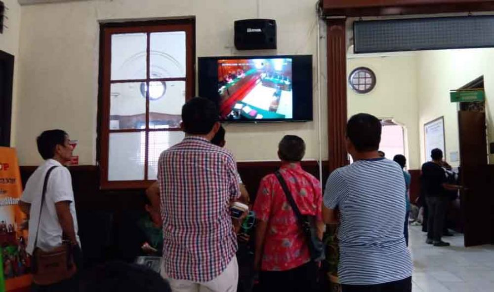 Pengunjung menonton persidangan Ahmad Dhani yang disediakan di ruang tengah PN Surabaya