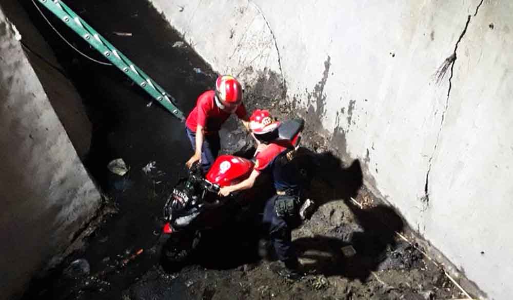 Petugas mengevakuasi motor yang nyungsep ke sungai