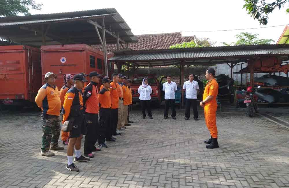 Petugas Kepolisian bersama warga membersihkan akses jalan dari longsoran batu.