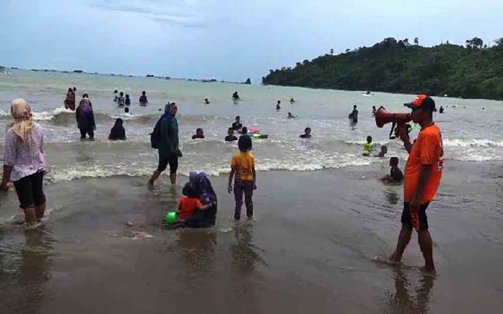 Petugas memperingatkan pengunjung pantai melalui pengeras suara