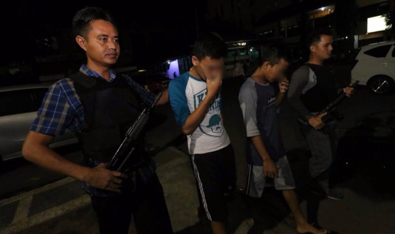 Dua pemuda saat ditangkap polisi.