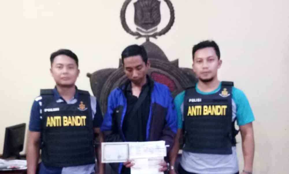 Pelaku (tengah) Saat Berada di Polsek Lakarsantri

