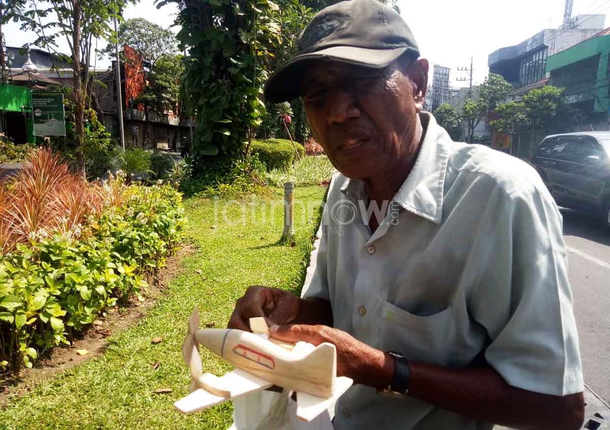Safii saat menjajakan maian pesawat kitirannya di Jalan Kertajaya Surabaya