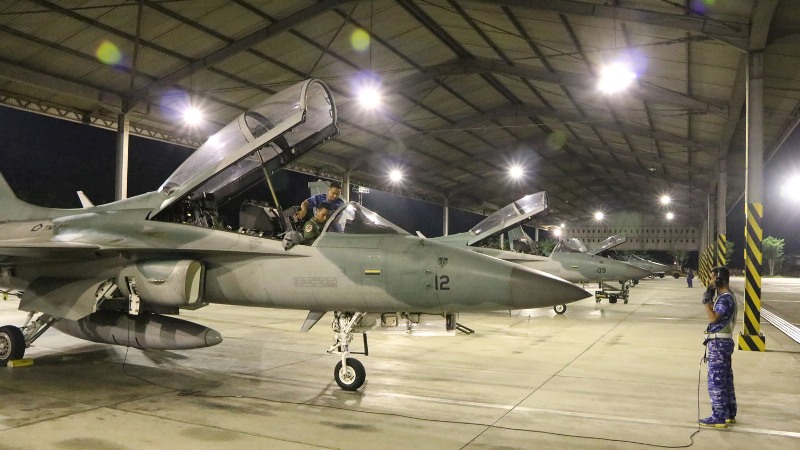 Ground crew menggunakan senter melihat kondisi pesawat sebelum take off pada latihan terbang malam, Senin (17/9/2018). 