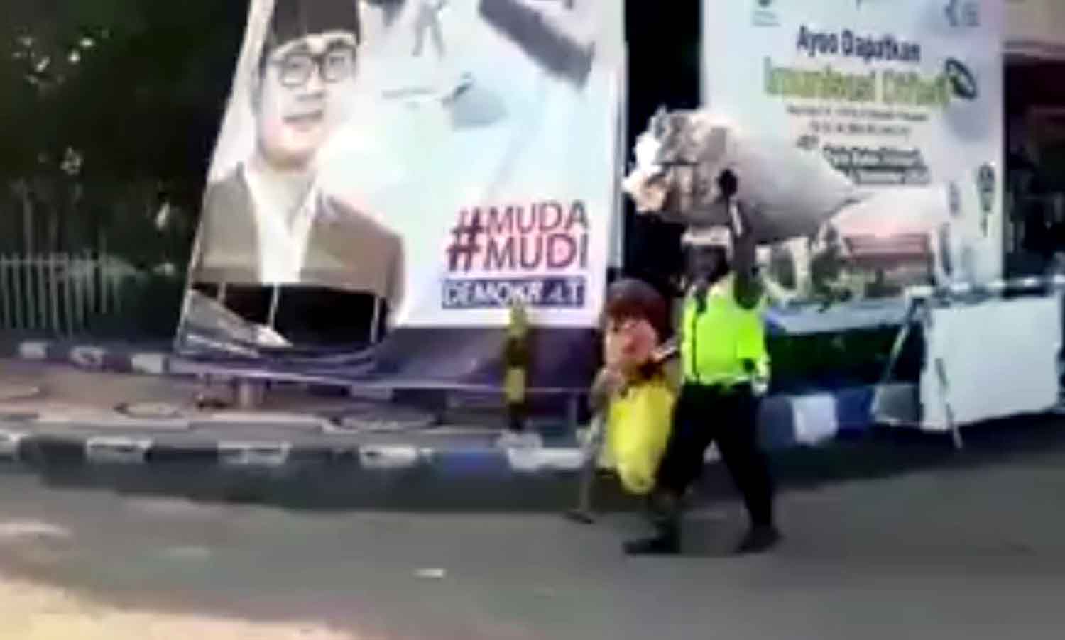 Bripka Suwaji membantu nenek pemulung menyeberang sembari membawa karung rongsokan