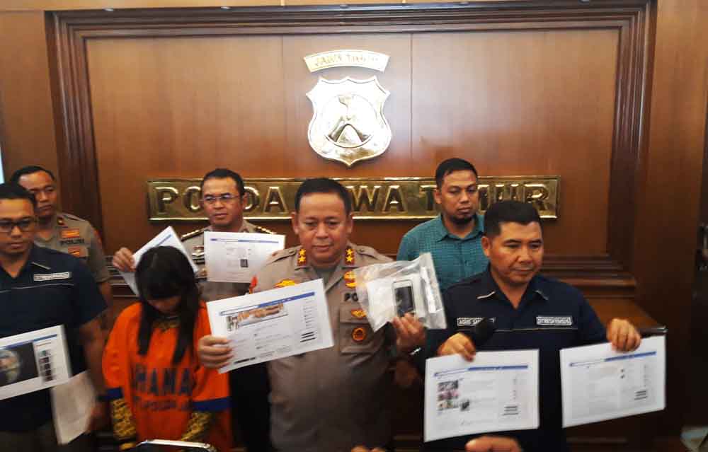 Tersangka (baju oranye) saat berada di Mapolda Jatim