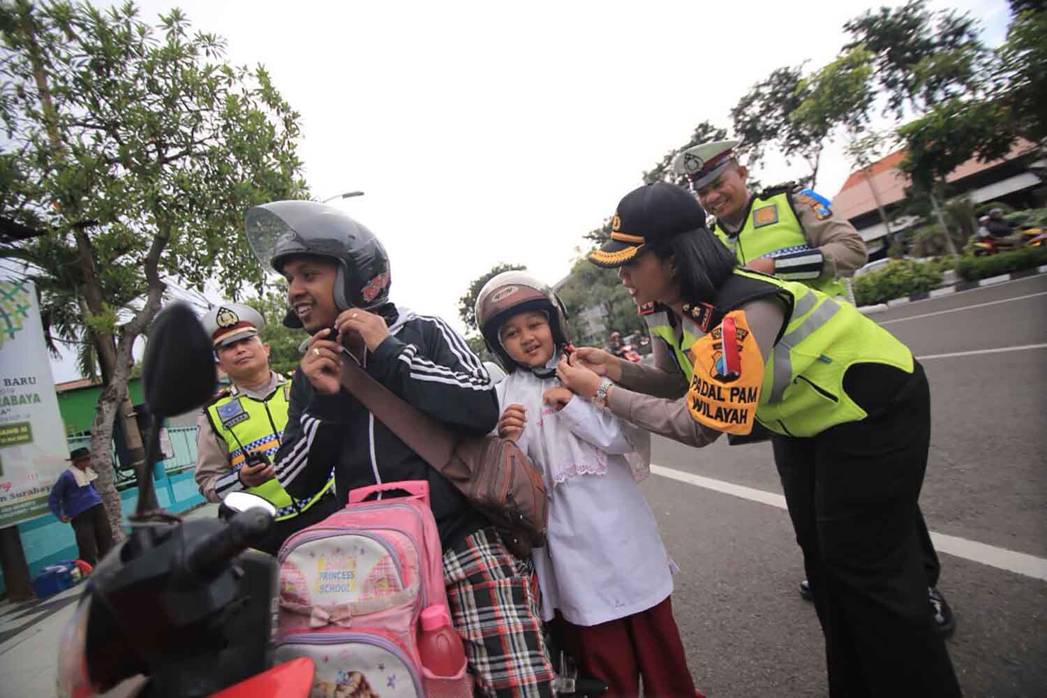 Kompol Dies Ferra memberikan bingkisan bagi anak-anak yang memakai helm. 