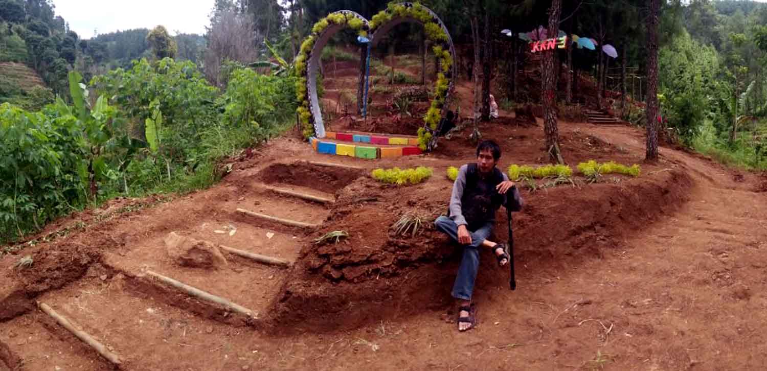 Seorang pengunjung sedang berpose di Bukit Pelangi
