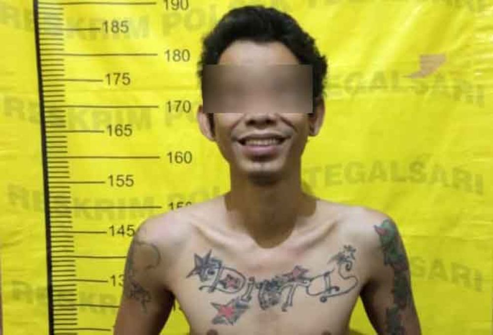 Permadi Joko Suwarno tersenyum saat difoto polisi