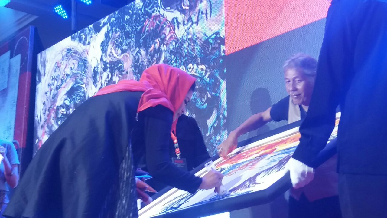Cawagub Puti saat melukis di sebuah kanvas