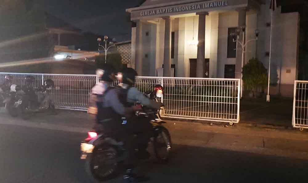 Polisi bersenjata lengkap saat masuk ke gereja 

