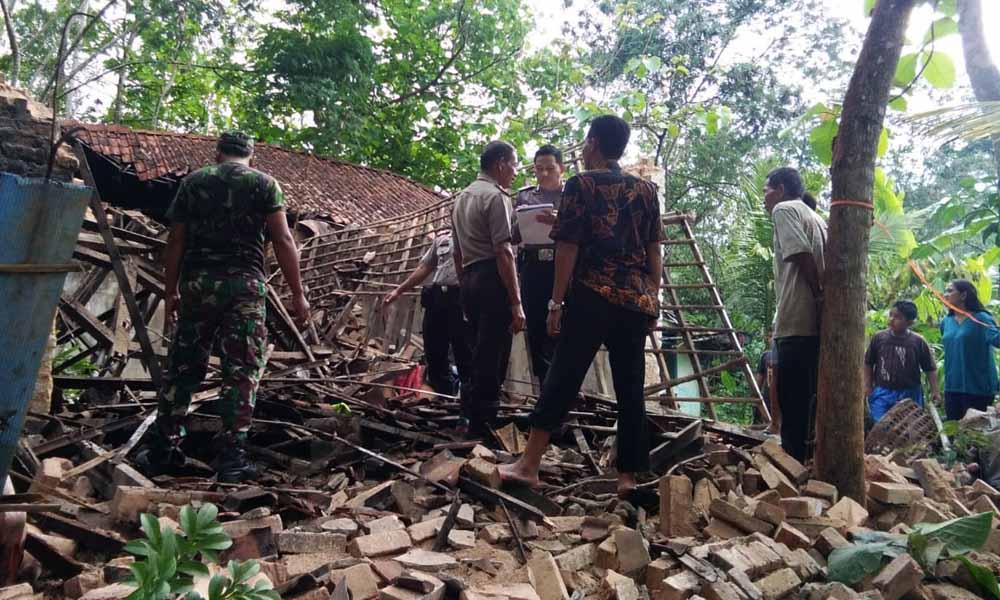 Warga dan petugas membersihkan puing-puing rumah ambruk