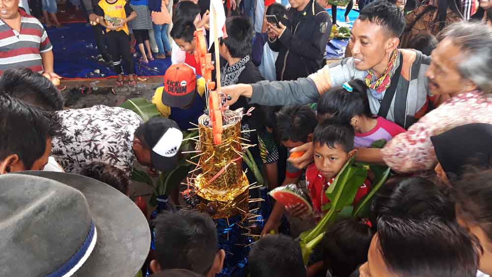 Warga saat berebut tumpeng  sedekah bumi di depan Balai RW Dukuh Bungkal, Sambikerep, Surabaya (16/9/2018)