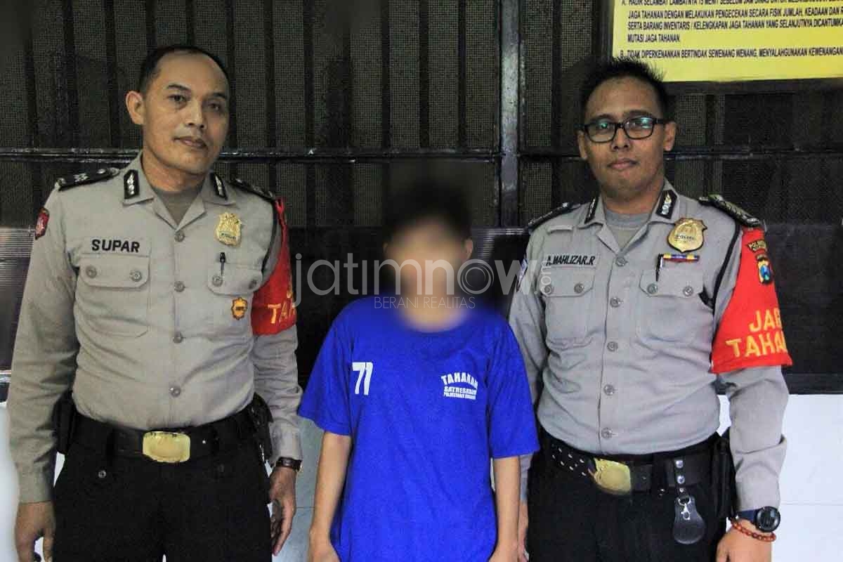 Kusmi (tengah) saat diamankan di Mapolrestabes Surabaya

