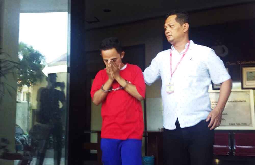 Tersangka bersama petugas polisi saat di Maporestabes Surabaya