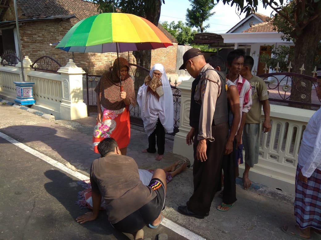 Petugas mengevakuasi korban yang masih tergeletak di pinggir jalan usai dikepruk batu, Jumat (14/9/2018).