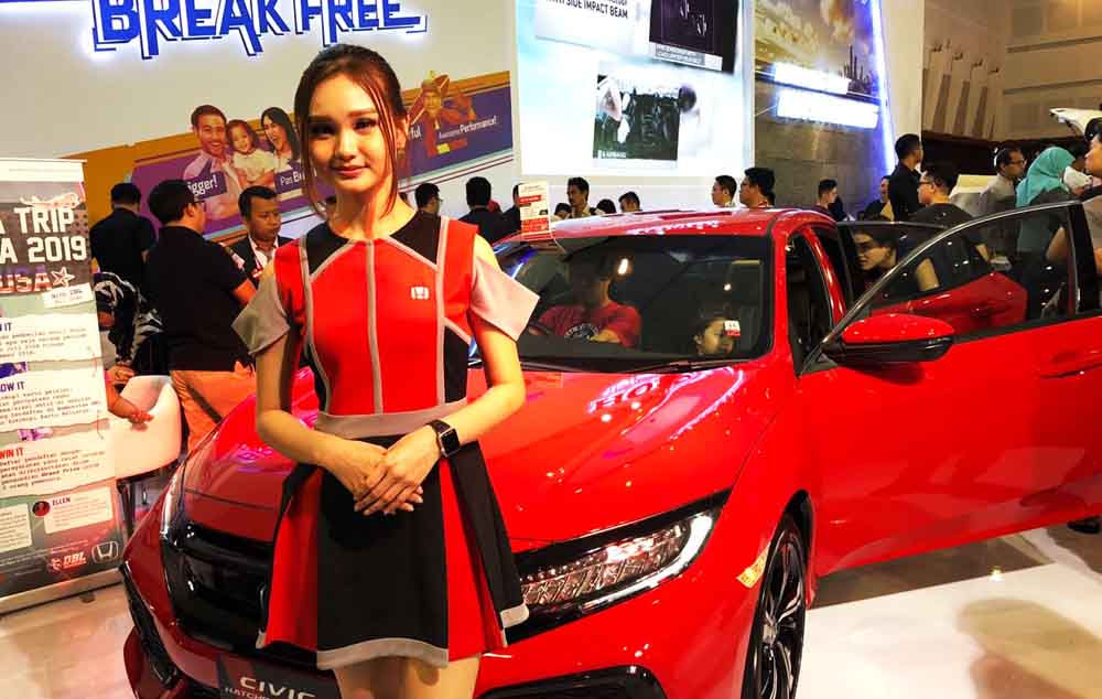 Salah satu Sales Promotion Girl berpose di depan mobil yang dipamerkan