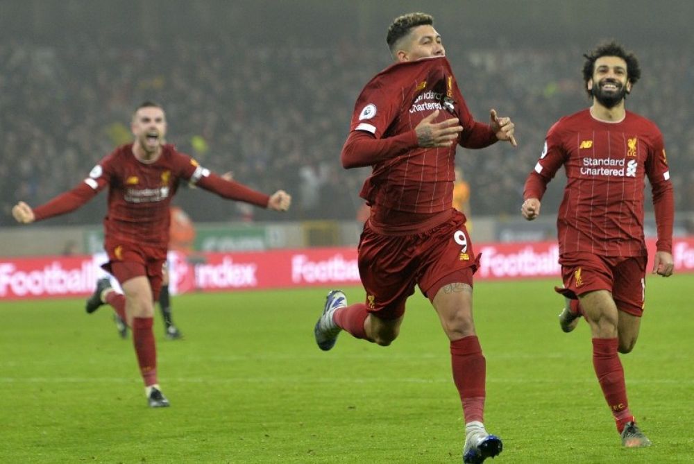Striker Liverpool Roberto Firmino (tengah) merayakan gol ke gawang Wolves bersama rekan setimnya, Mohamed Salah (kanan) dan Jordan Henderson (kiri)  (Foto: EPA/PETER POWELL)