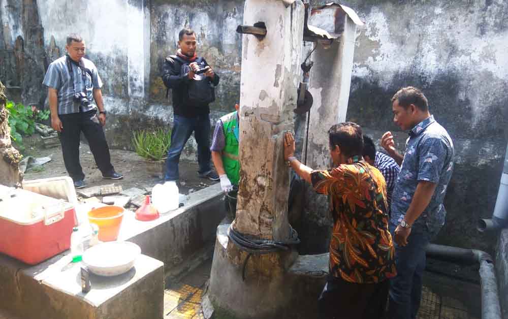 Petugas Polsek Pungging saat mengecek sumur di belakang rumah Isti Mesriawan.