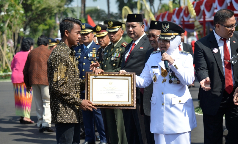 Supriadi saat menerima penghargaan dari Risma/Foto: istimewa