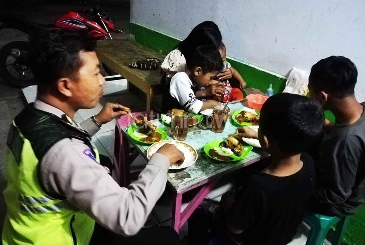 Seorang petugas Sat lantas Polres Ponorogo mengajak ibu dan anak-anaknya yang tersesat makan sebelum mengantar pulang