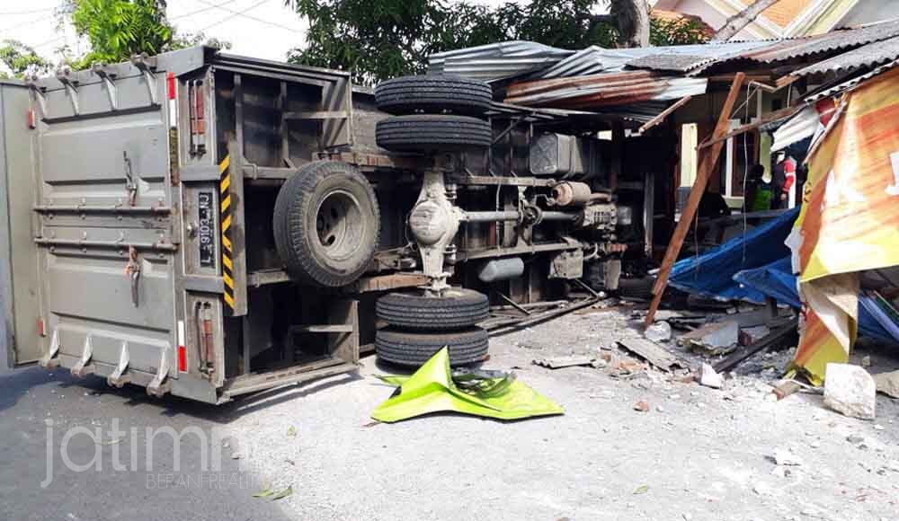 Kondisi truk terguling usai menabrak warung kopi
