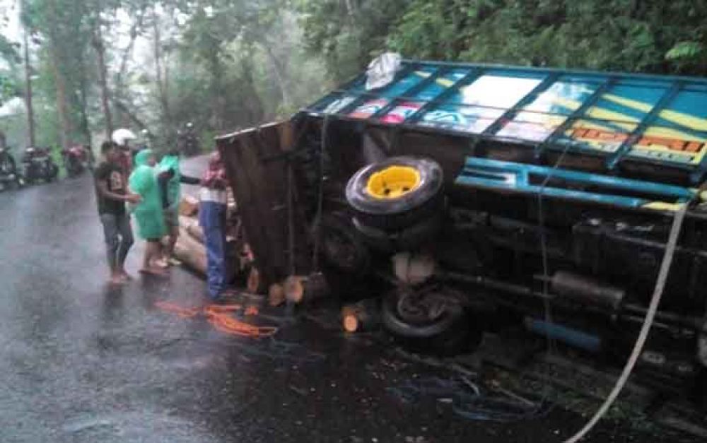 Truk memuat kayu terbalik